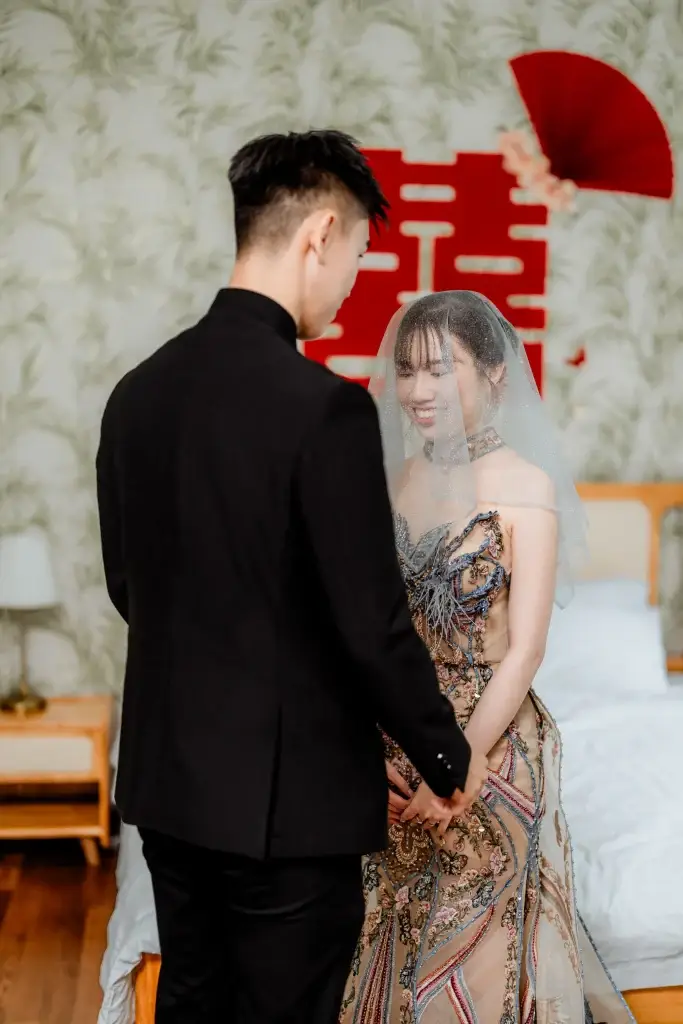 Chinese wedding couple indoors with red fan and double happiness symbol, styled and captured by wedding photographer Struck By Luna in Penang.