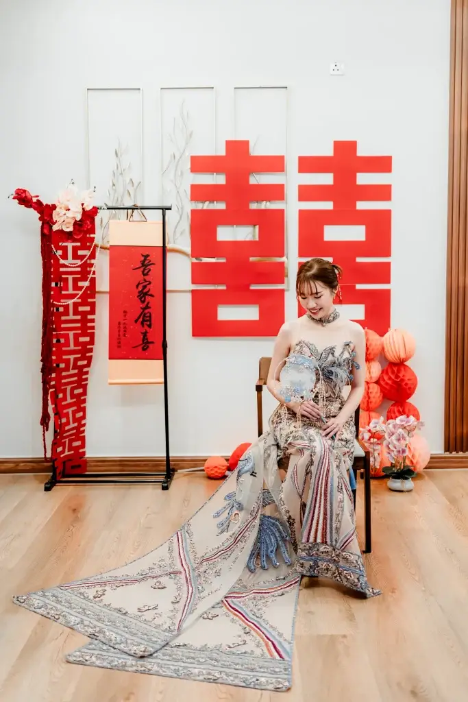 Chinese wedding portrait in Penang with bride in traditional dress and red “double happiness” backdrop—styled and captured by wedding photographer Struck By Luna.