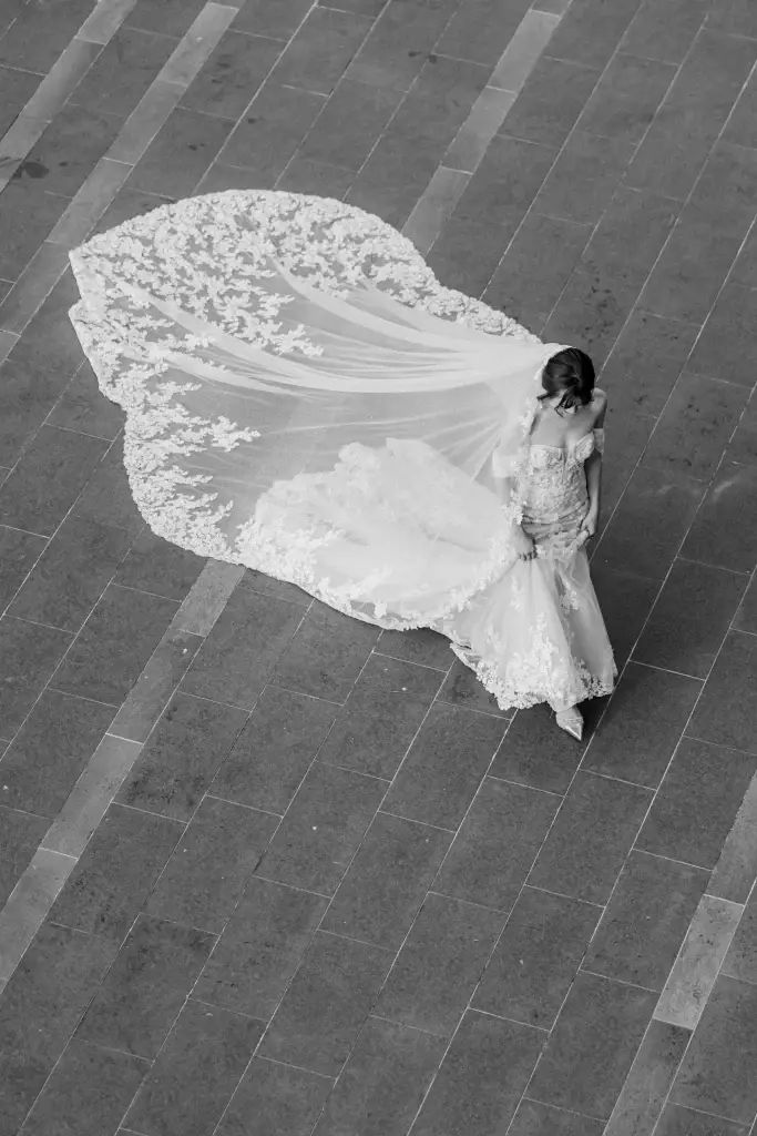 Artistic black and white shot of a bride in a lace wedding gown, photographed from above on patterned tiles in Penang, Malaysia—captured by Struck By Luna