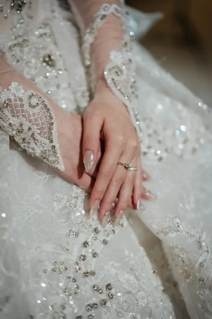Bride’s hands resting on an embellished white lace and ring wedding gown —photographed in Penang, Malaysia by Struck By Luna.
