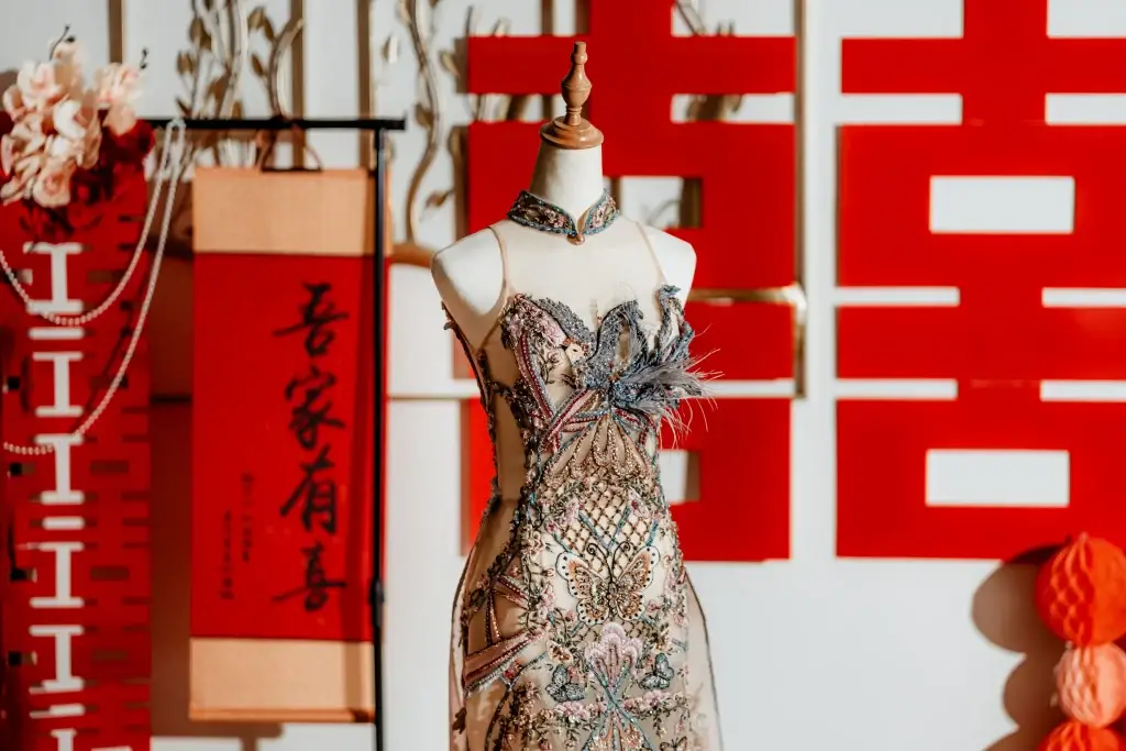 Chinese wedding display with red backdrop, floral fan dress on mannequin, and gold characters—styled and captured by wedding photographer Struck By Luna in Penang.