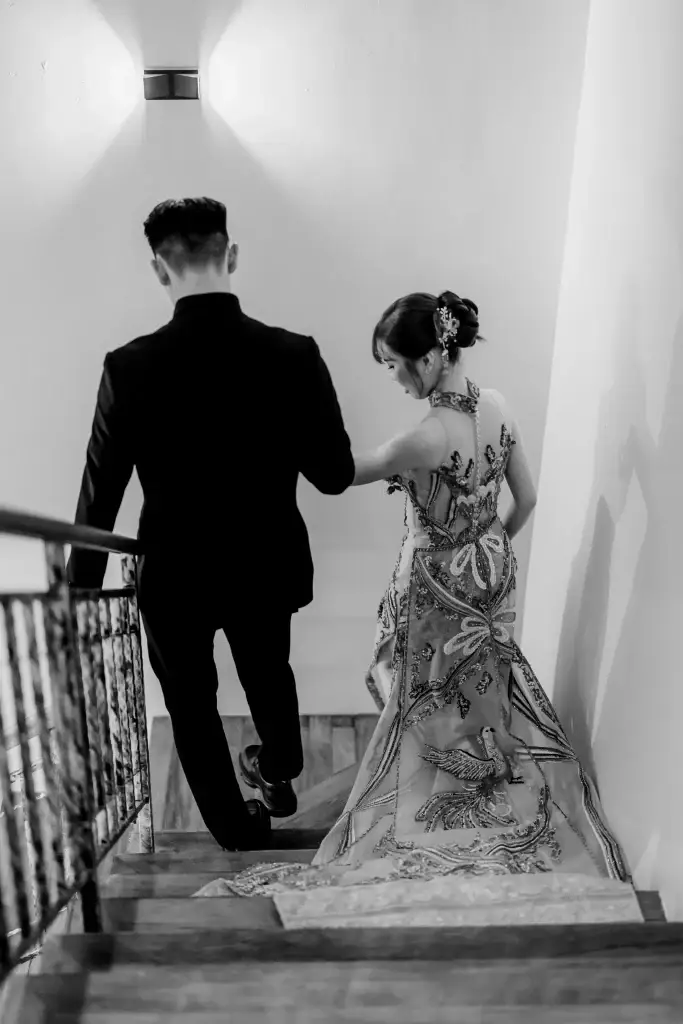 Bride and groom descending staircase in Penang, captured in black and white by wedding photographer Struck By Luna.